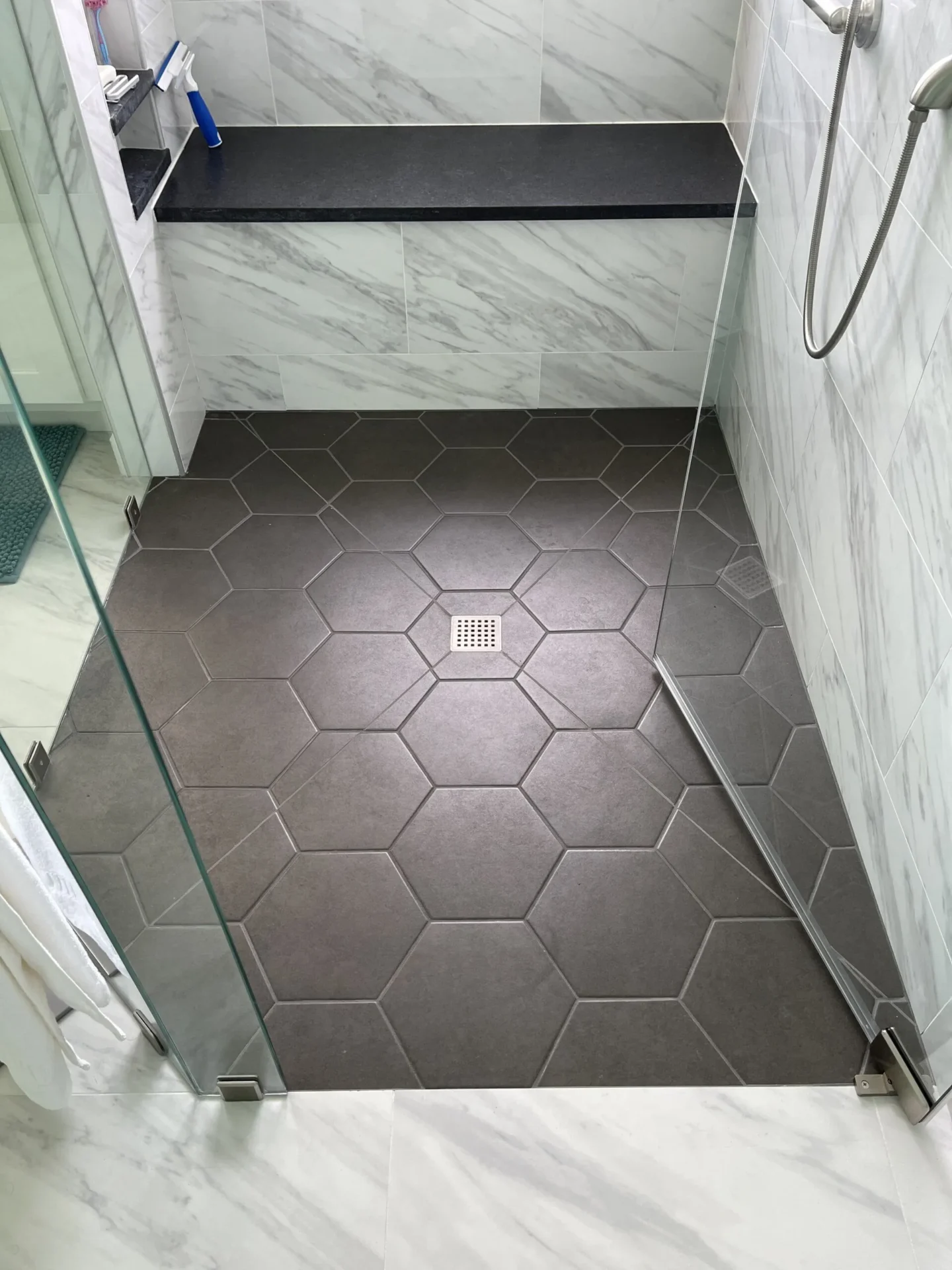 A bathroom with a shower and tiled floor.