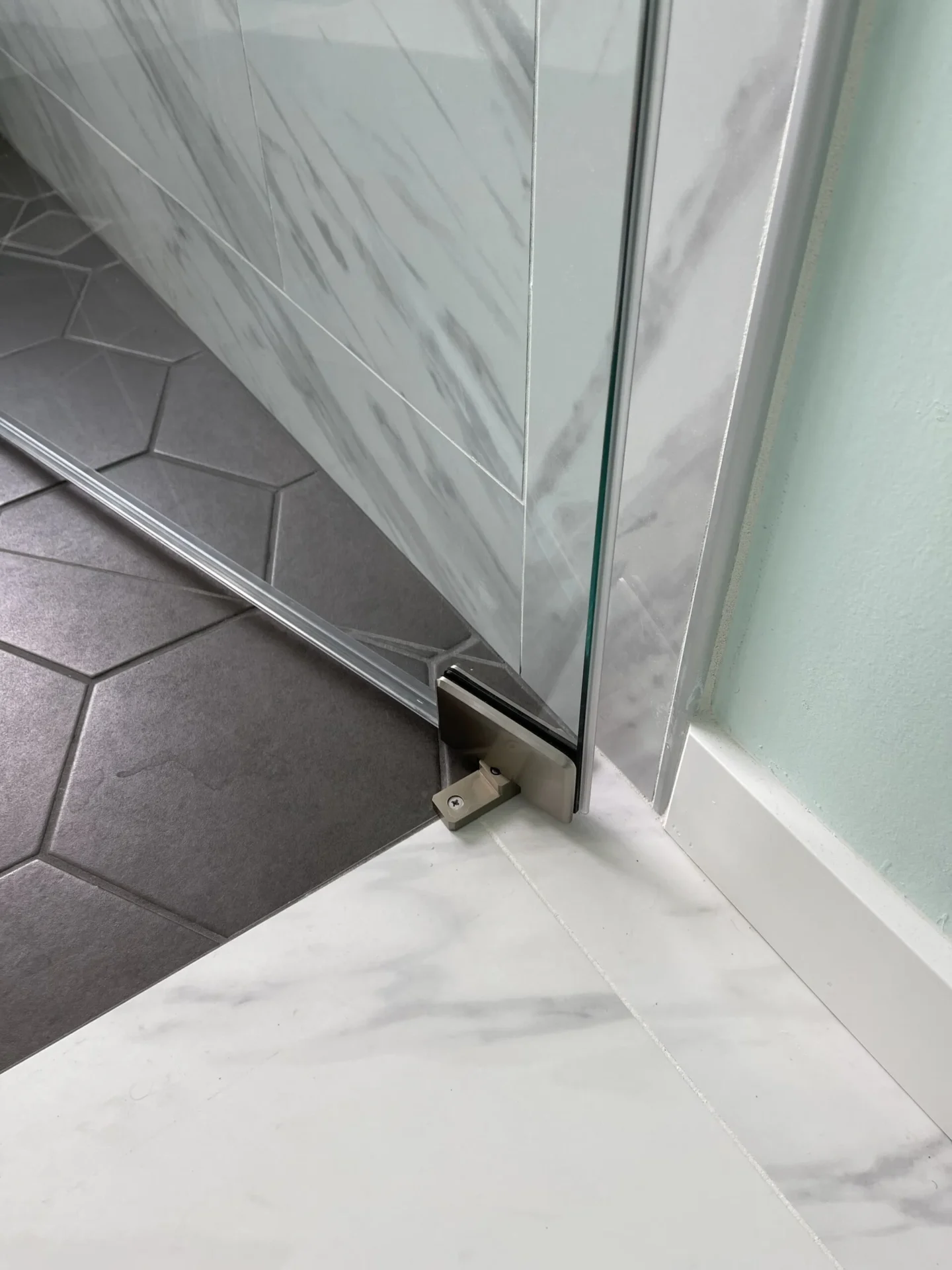 A corner of a bathroom with the shower door open.