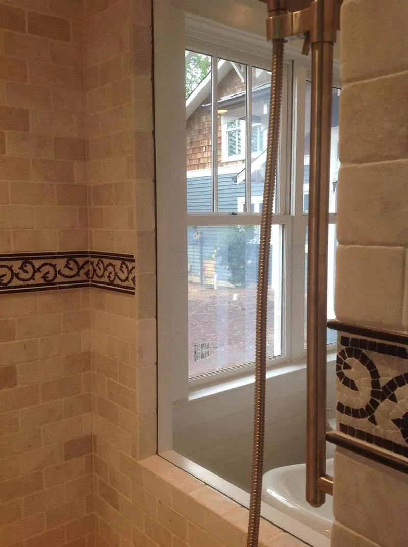 A bathroom with a shower and tiled walls.