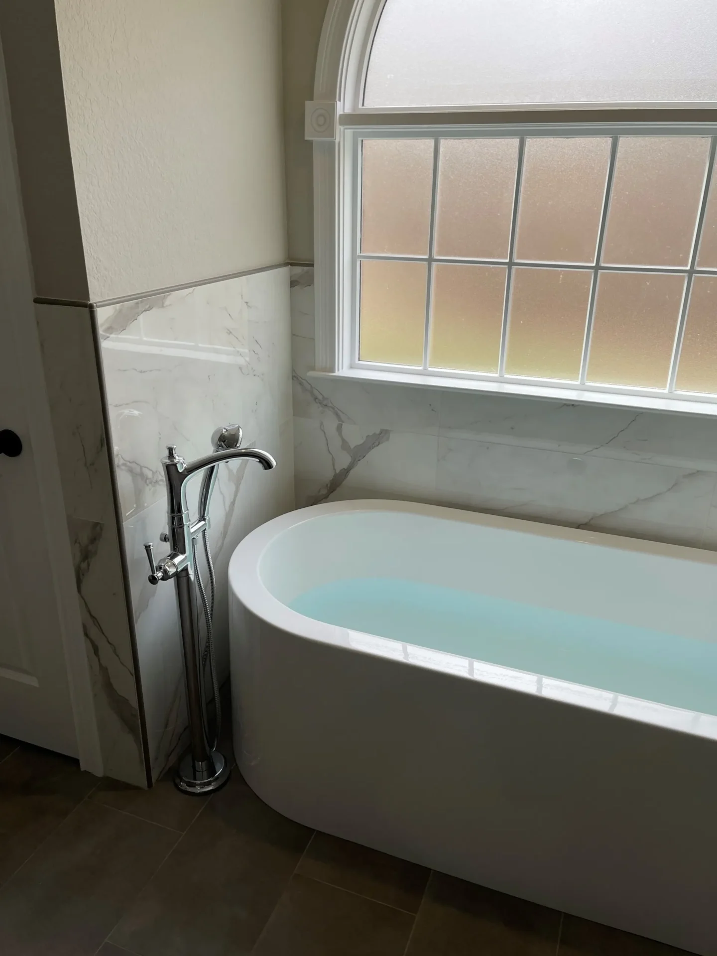 A bathroom with a tub and window in it