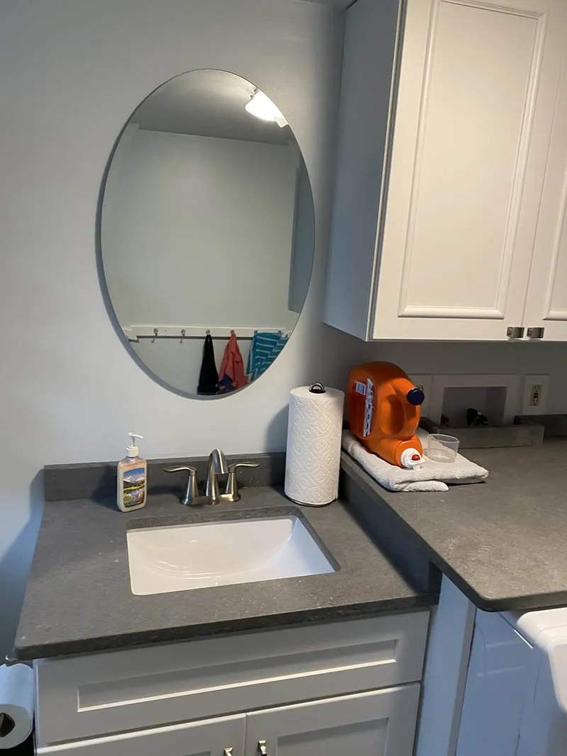 A bathroom with a sink and mirror in it