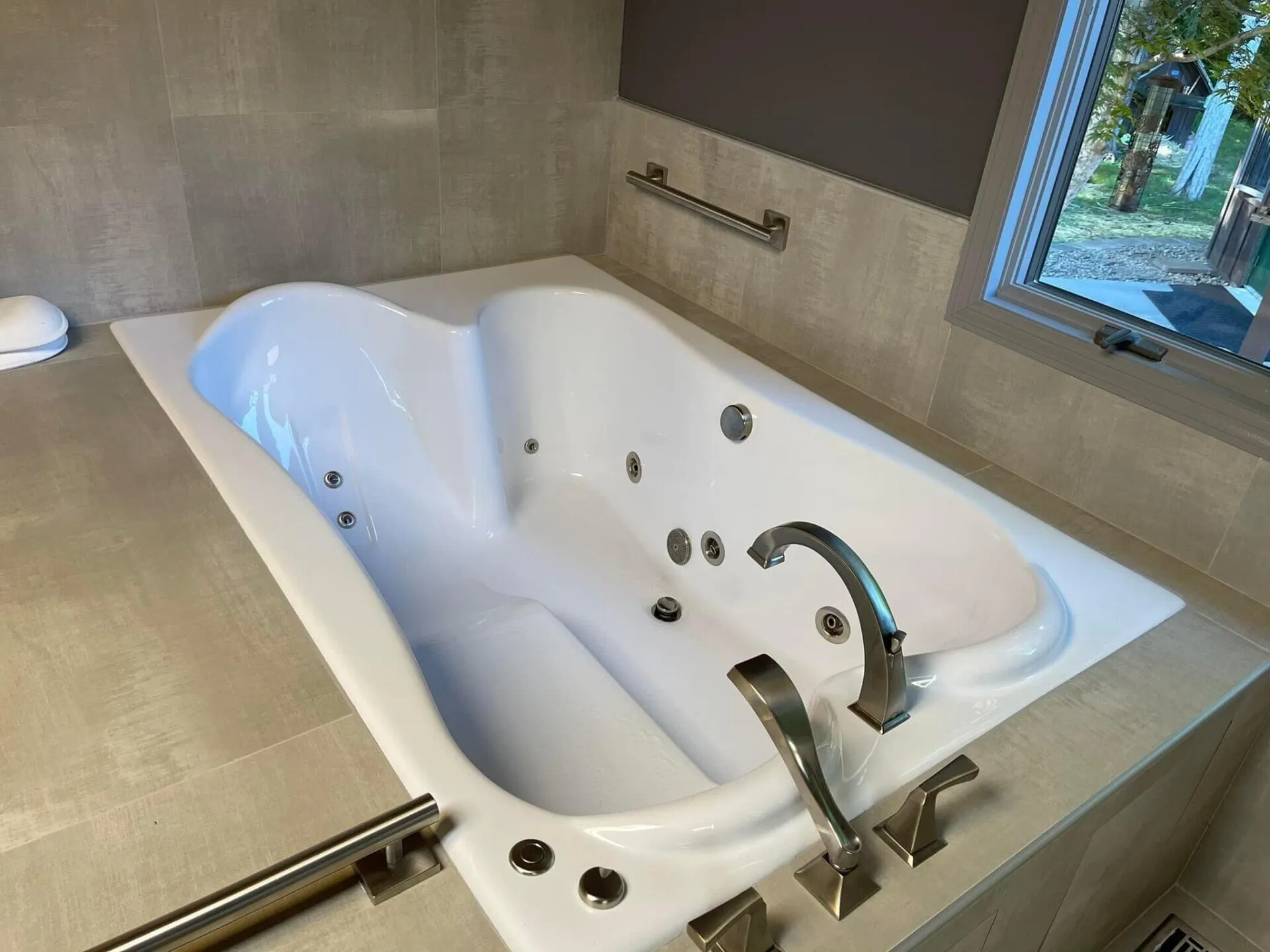 A large white tub sitting in the middle of a bathroom.