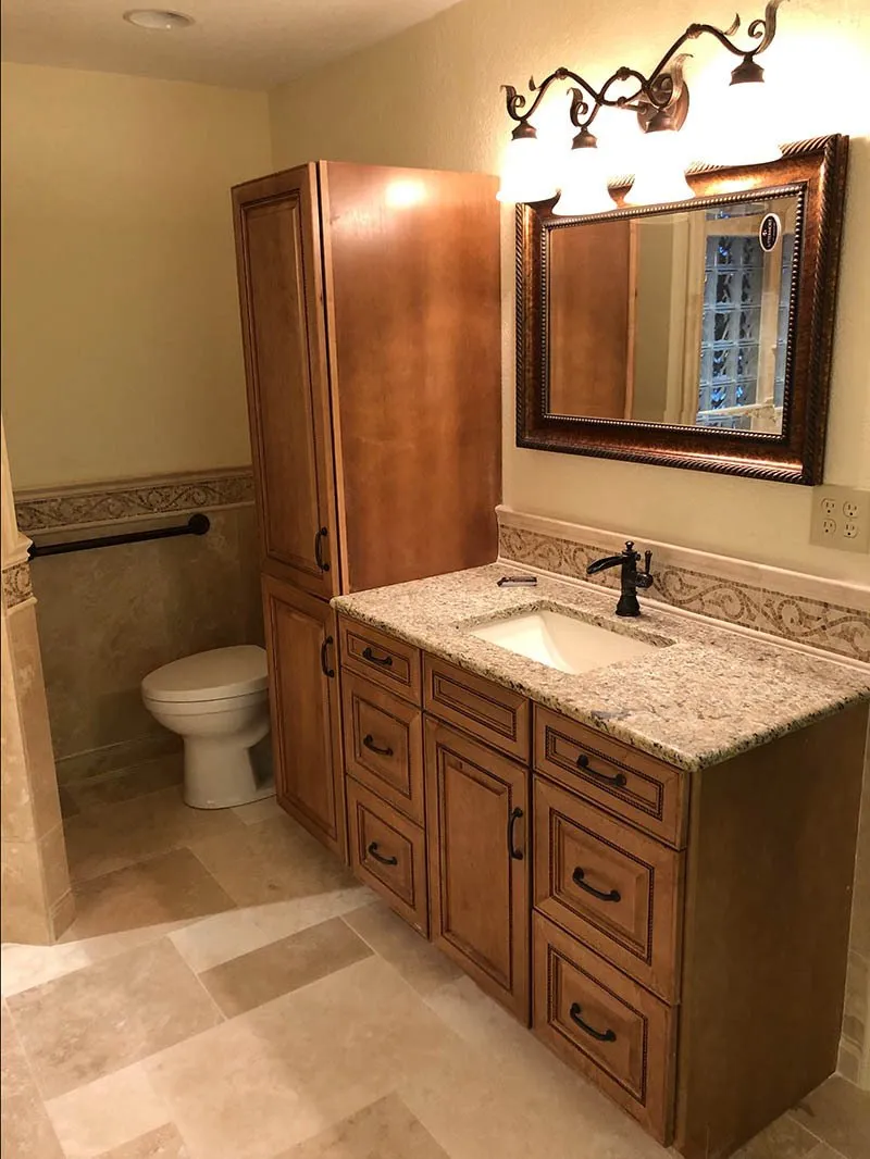 A bathroom with a toilet, sink and mirror.